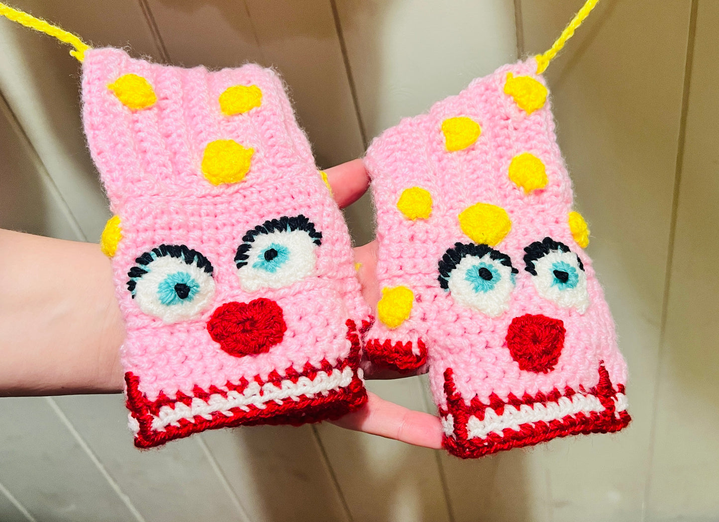 Mr Blobby themed crocheted gloves on a string